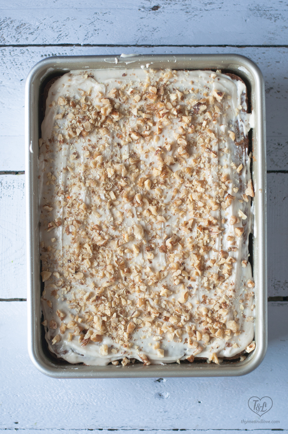 Moist, tender Zucchini Carrot Cake topped with a light cream cheese frosting and chopped walnuts. 