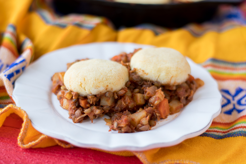 Warm, homey vegan + gluten-free casserole. Lentil Picadillo is topped with light, fluffy arepa biscuits. 
