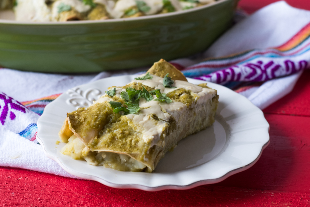 These Potato and Roasted Enchiladas are inspired by Mexican papas con rajas. The combination of the potatoes with the spicy poblanos is so good! #vegan #mexican 