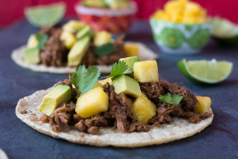 Slow Cooker Beer Braised Jackfruit Tacos topped with avocado, pineapple and cilantro. 