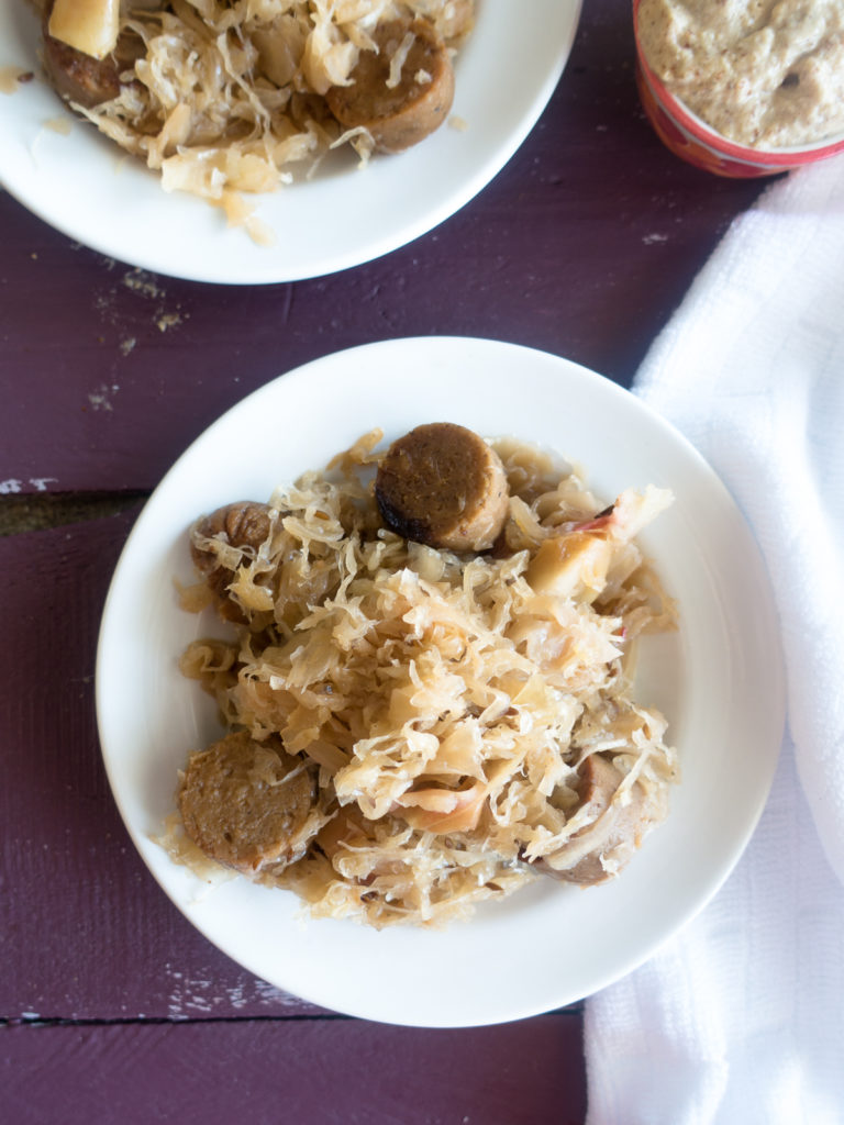 This Vegan Sauerkraut and Bratwurst Casserole is a cozy casserole that is perfect for the cooler weather. It is loaded with vegan bratwurst sausages, onion, apples, and lots of sauerkraut! #vegan #dinner #recipe #entree #apples #sausages #fall #food #sauerkraut 