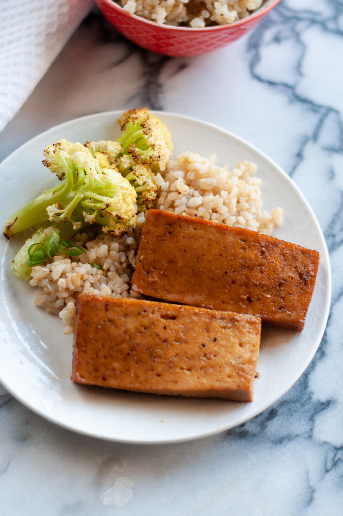 Slices of tofu are baked in a sweet and tangy Asian ginger glaze. This glaze is a little sweet and sticky. #tofu #vegan #recipes #easyrecipes #food #Asian #plantbased 