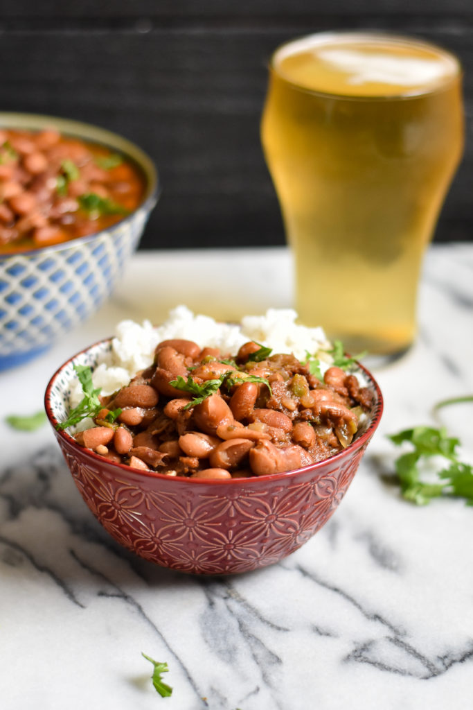 Pinto beans are cooked in a flavorful broth of beer and spices. The Instant Pot makes cooking beans so easy! #beans #Mexican #vegan #frijoles #VeganMexican