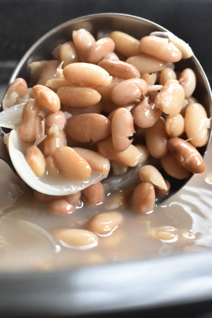 Pinto beans are cooked with white onion, garlic and a jalapeño. As the pinto beans cook in the slow cooker, the absorb all the flavors from the onion, garlic and jalapeño. 