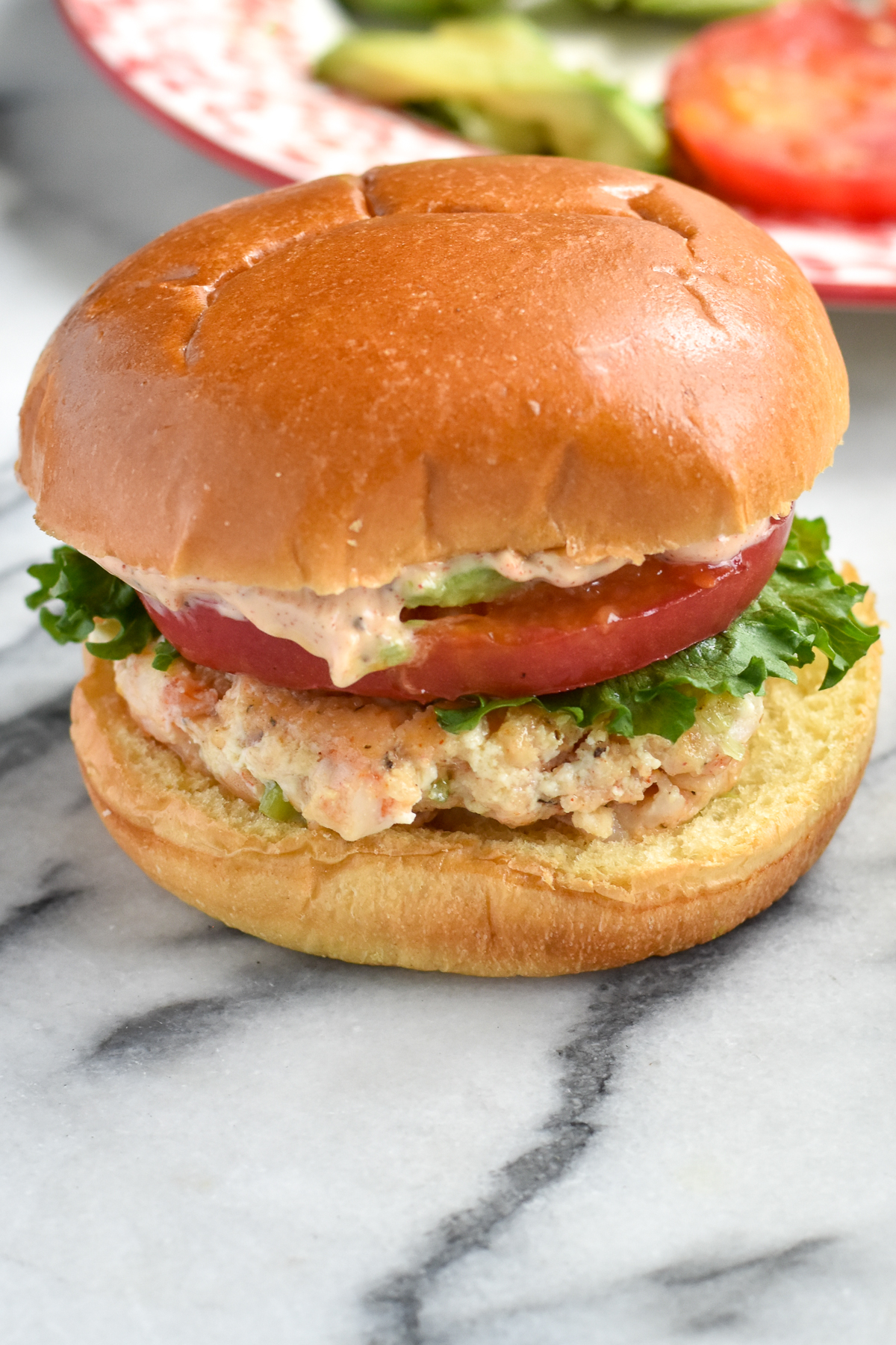 Flavorful, tender Shrimp Burgers are a light, alternative to a traditional beef burger. The burgers are topped with avocado, tomato and lettuce.