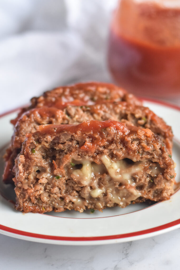 Whether you are vegan or just just someone who just likes to incorporate a few meatless meals into your diet—this vegan meatloaf is great plant-based dinner to add to your meal plan. Vegan meatloaf stuffed with cheese and served with marinara sauce. 