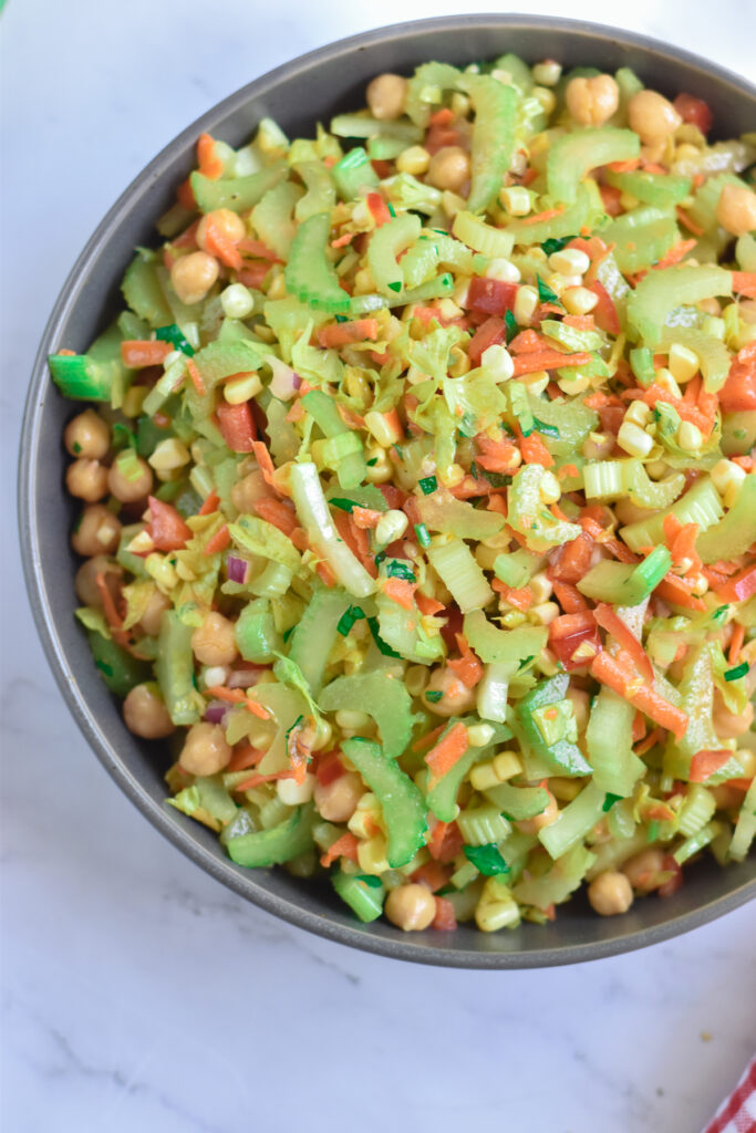 Healthy, plant-based chickpea salad with lots of fresh vegetables tossed in a light olive oil based dressing. 